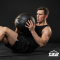 Abdominales con Medicine Ball de 9 kg en estudio oscuro